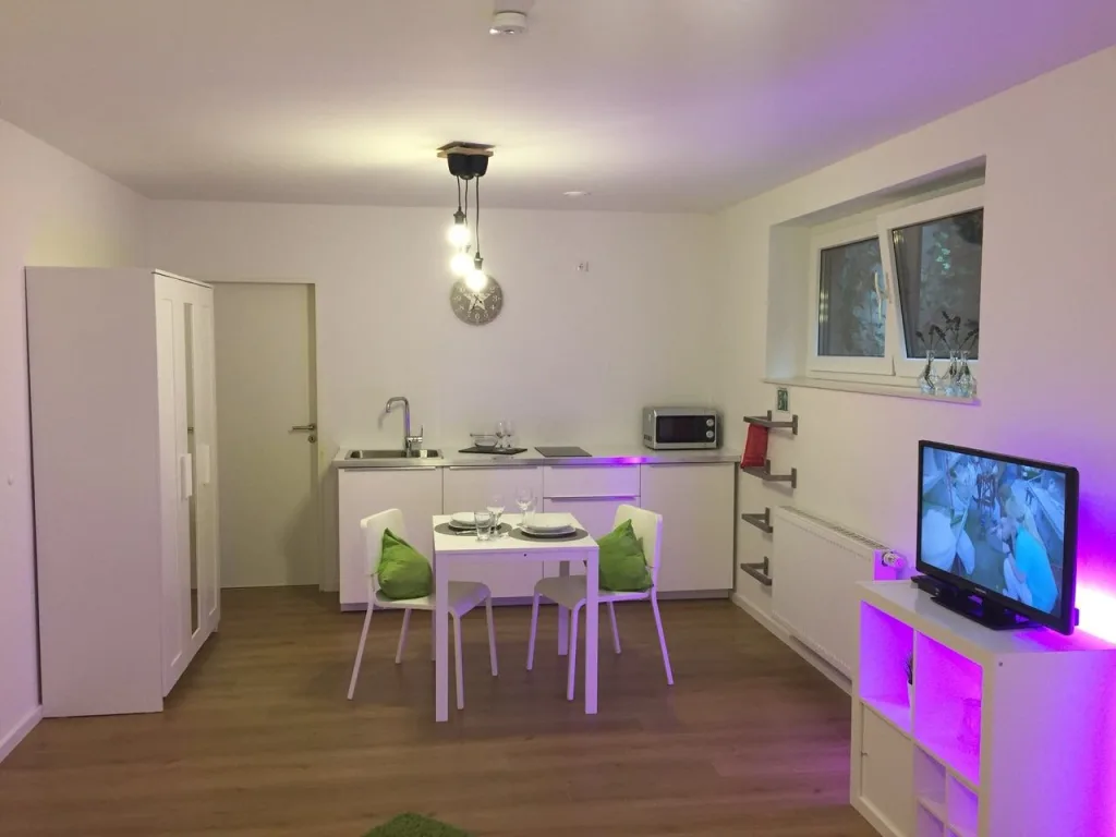 Offener Küchen- und Wohnbereich der Wohnung 0.1 mit indirekter Beleuchtung