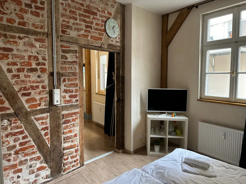 Schlafbereich der Kuhviertelstube mit Bett vor der Backsteinwand