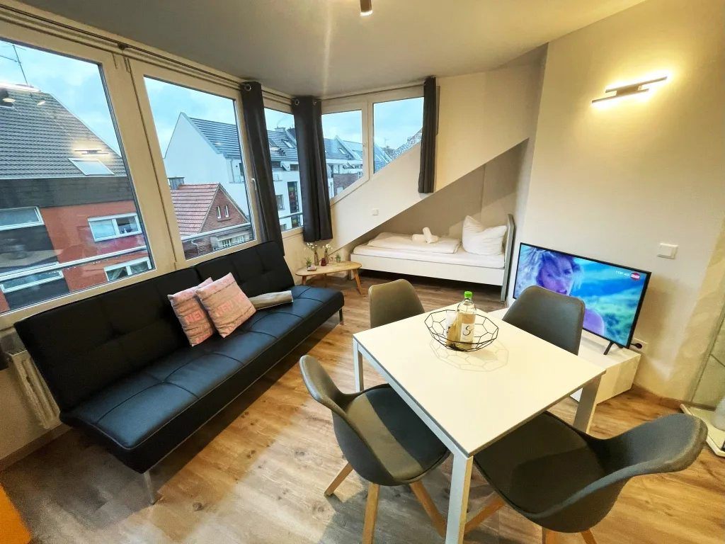 Wohnbereich der Freundschaft mit Sofa und Esstisch unter der Dachschräge