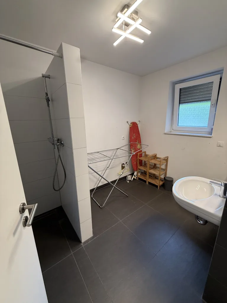 Badezimmer der Wohnung 2 mit bodenebener Dusche und WC