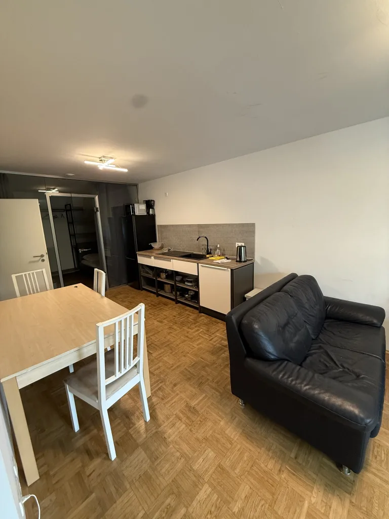 Essbereich der Wohnung 2 mit Tisch, Stühlen und offener Küchenzeile