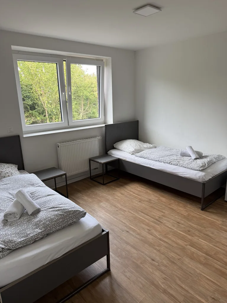 Erstes Schlafzimmer der Wohnung 4 mit zwei Einzelbetten am Fenster