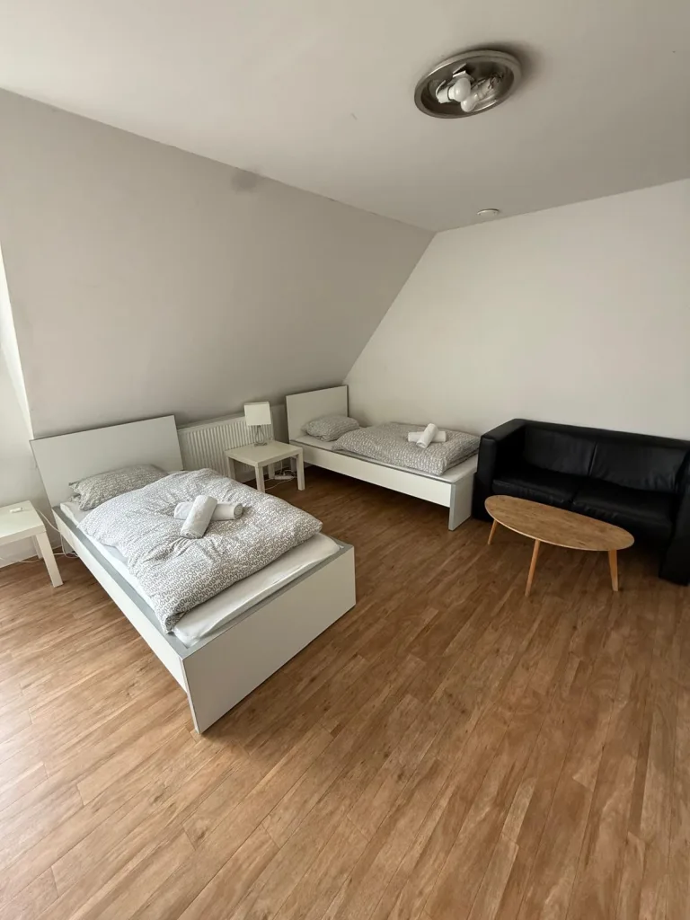 Zwei Einzelbetten der Wohnung 6 mit Nachttisch unter der Dachschräge