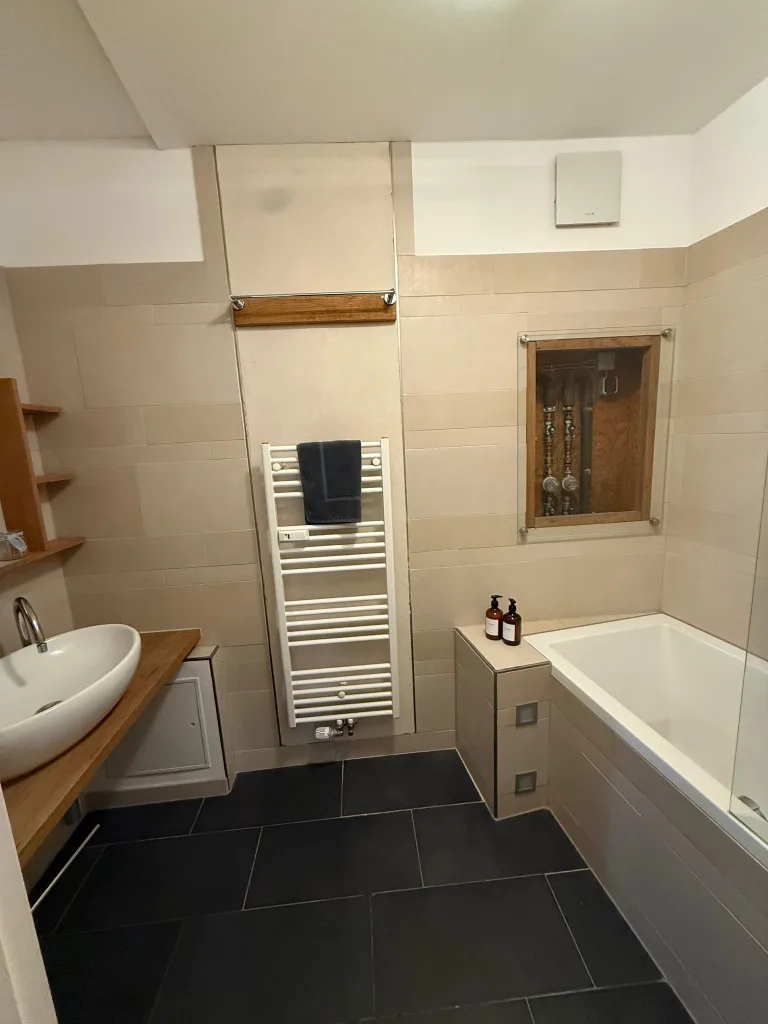 Badezimmer der Leezen mit Badewanne, Handtuchheizkörper und Waschtisch