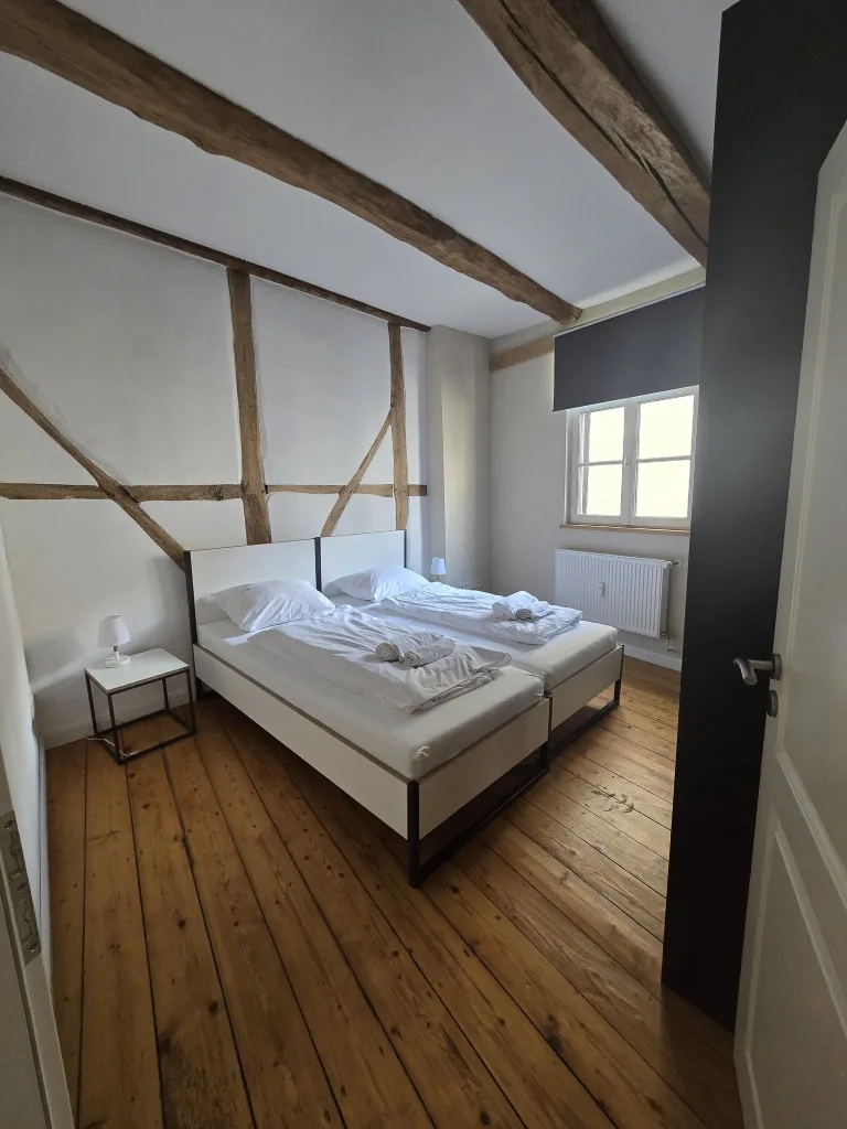 Schlafzimmer der Leezen mit Doppelbett unter dem Fachwerk