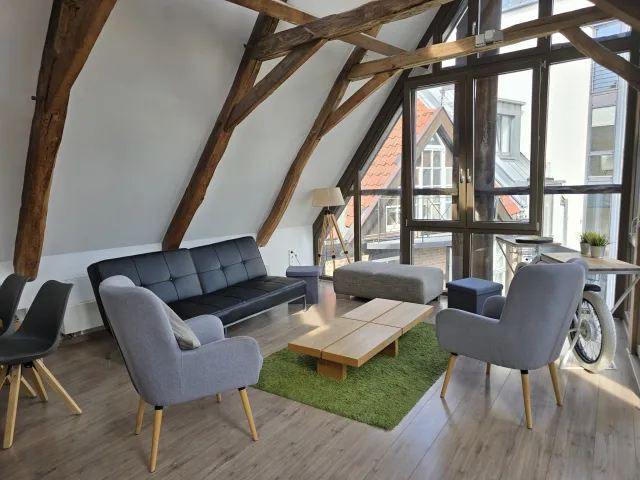 Wohnbereich des Lemperlofts mit Sofa, Sesseln und großer Fensterfront