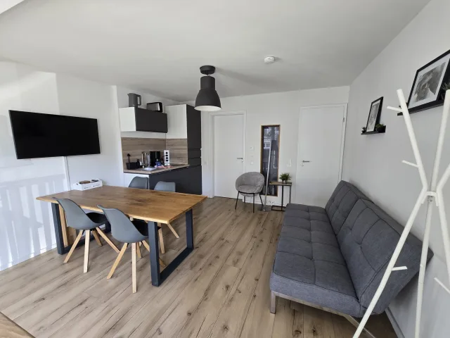 Wohnbereich von Family & Friends mit Esstisch, Sofa und Fernseher