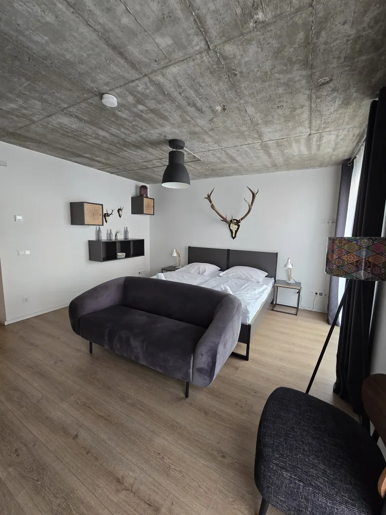 Doppelbett und Sofa im Leezennest unter der Betondecke