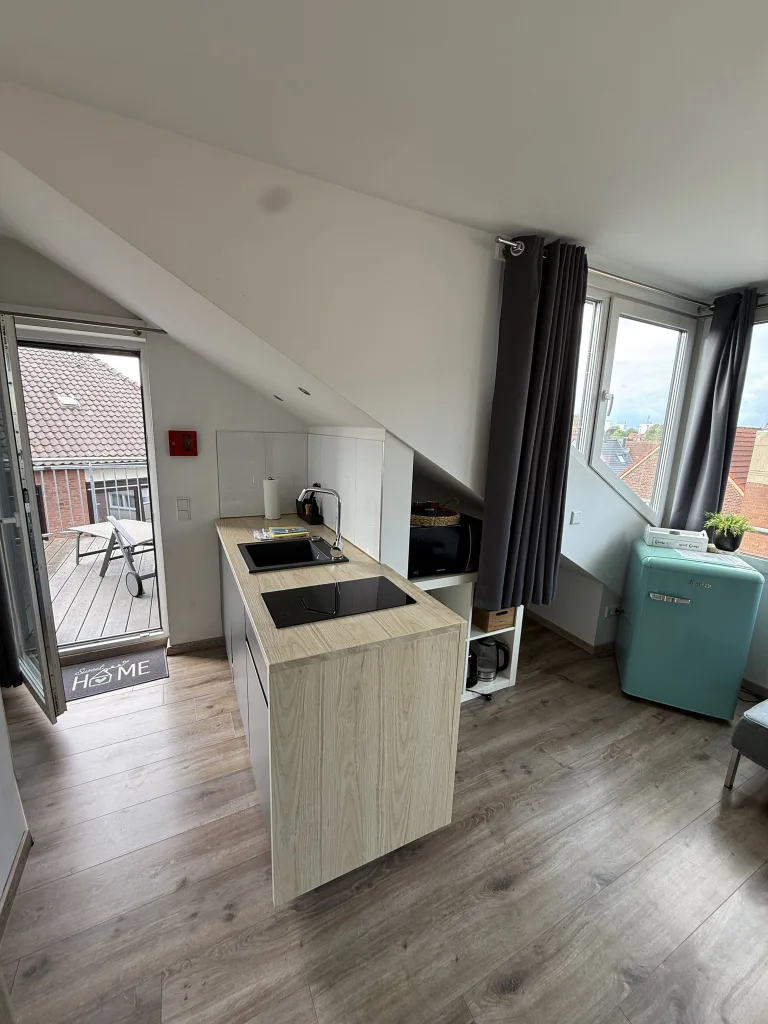 Küchenzeile des Münsterblicks mit Kühlschrank und Balkontür