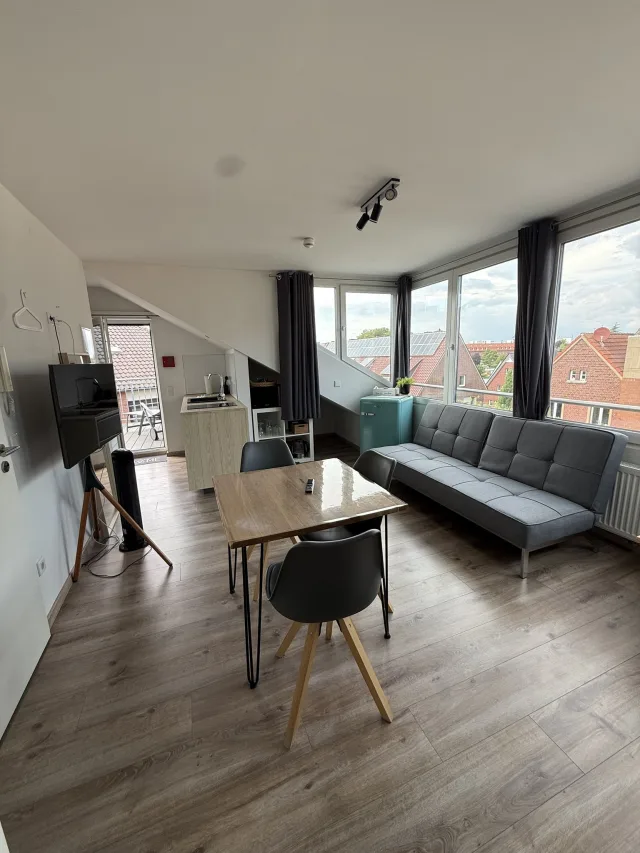 Wohnbereich des Münsterblicks mit Sofa, Esstisch und Fensterfront