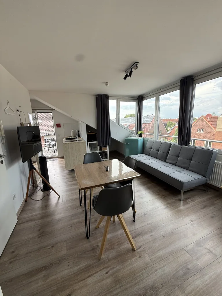 Wohnbereich des Münsterblicks mit Sofa, Esstisch und Fensterfront