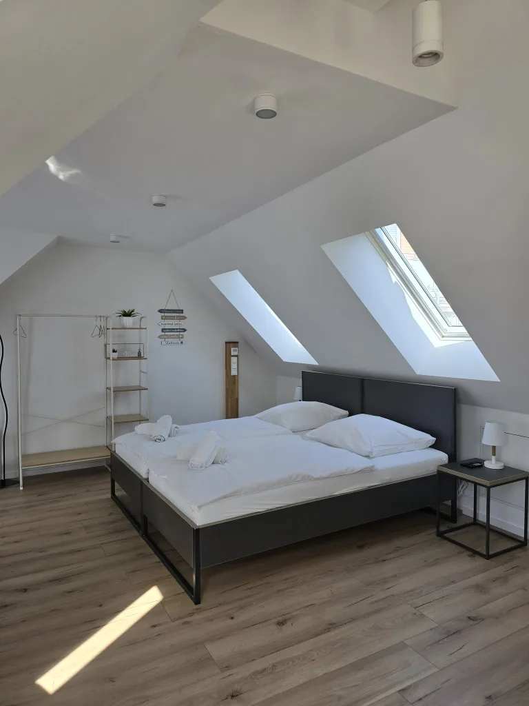 Schlafbereich des Münsternests mit Doppelbett unter dem Dachfenster