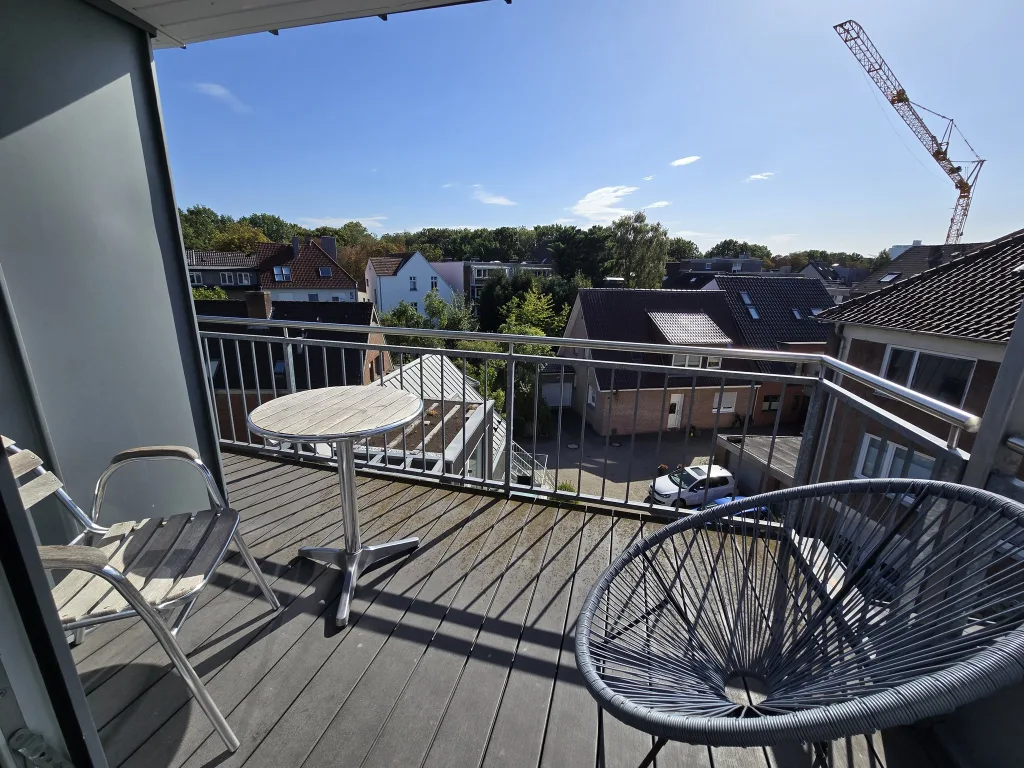 Balkon des Schlossgartens mit Tisch und Stühlen über den Dächern