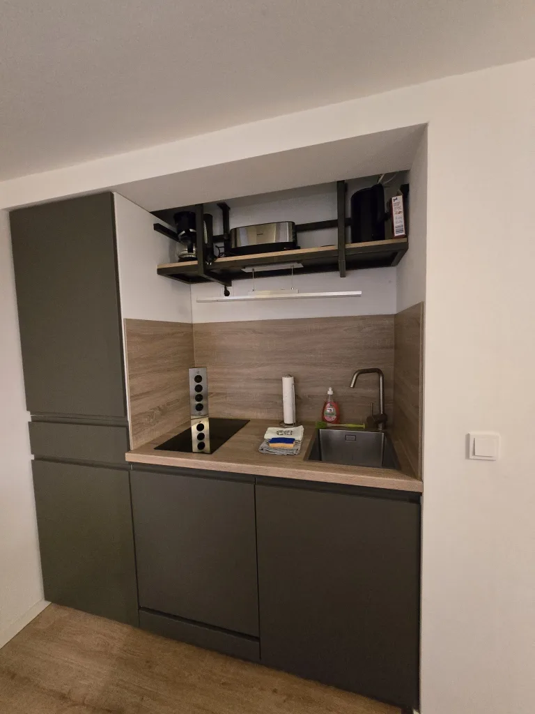 Küchenzeile des Stadtverstecks mit Holzrückwand und Kochfeld