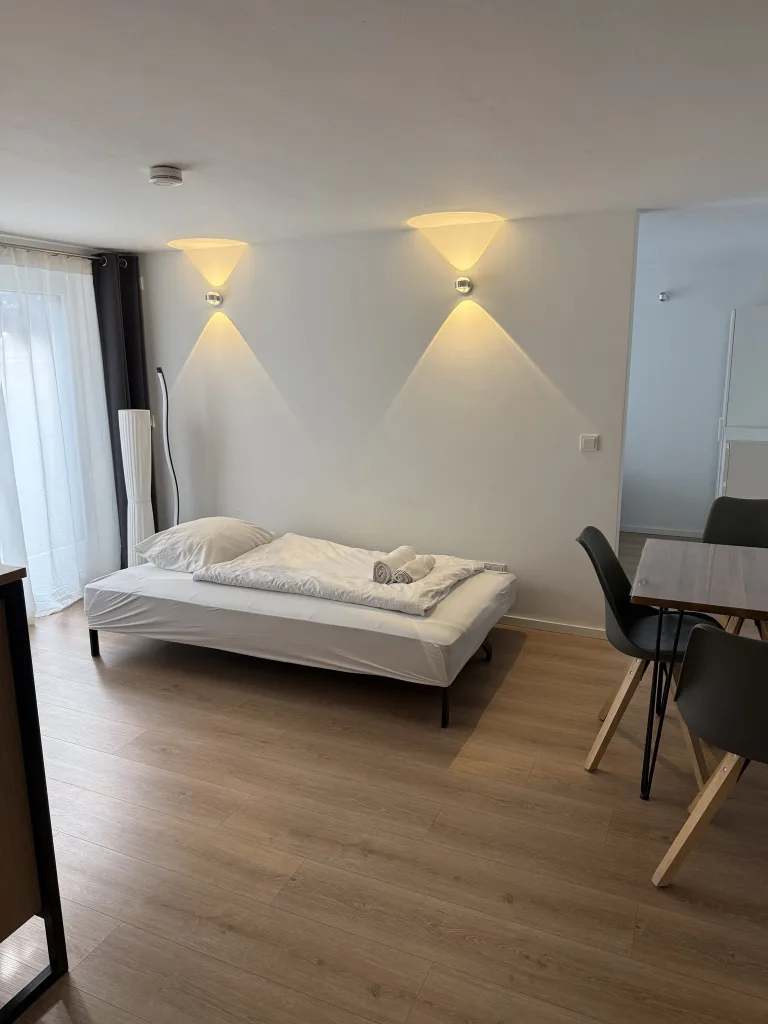 Wohnbereich des Stadtverstecks mit Couch, Esstisch und Wandleuchten