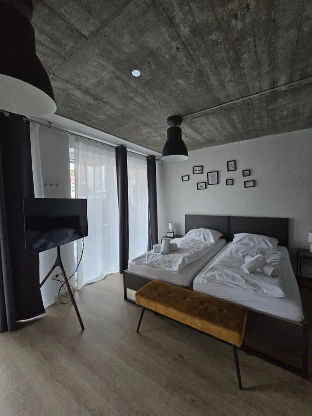 Wohnbereich des Viertelnests mit Fernseher, Bett und Fenster zum Innenhof